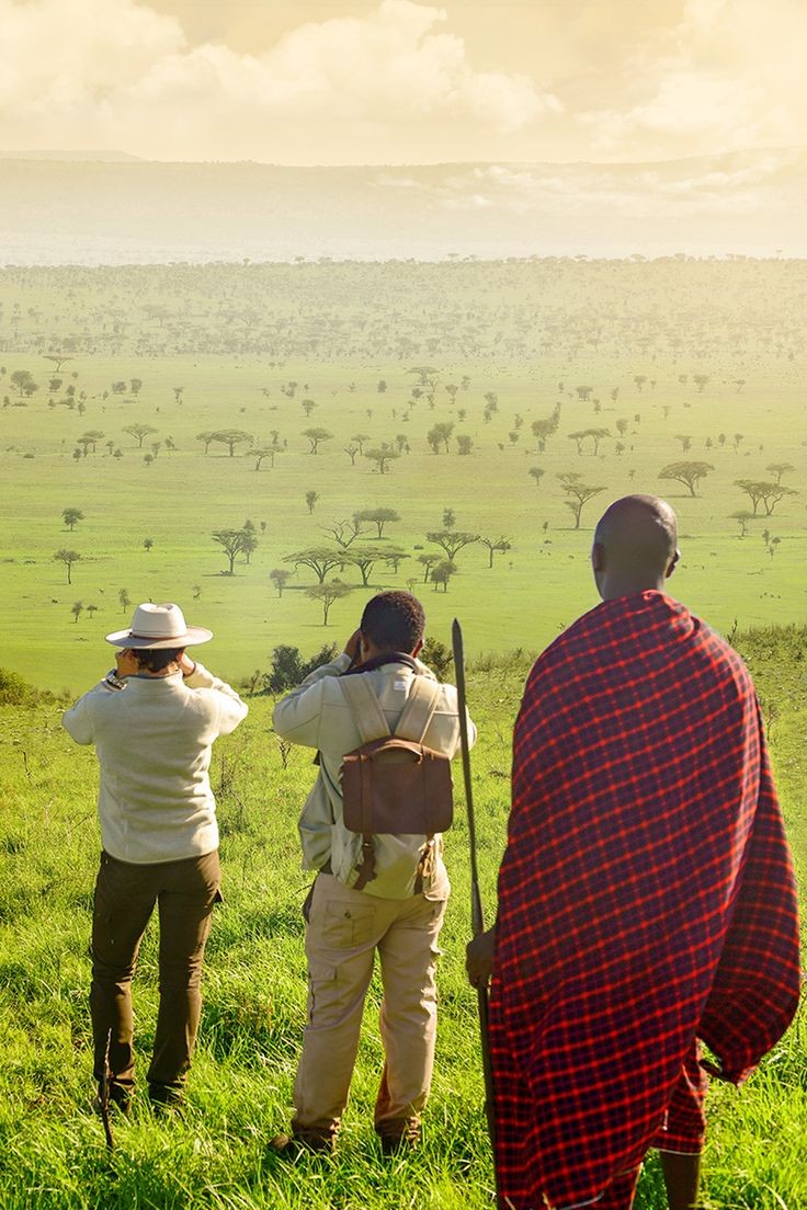 Safari guide scanning the plains with binoculars